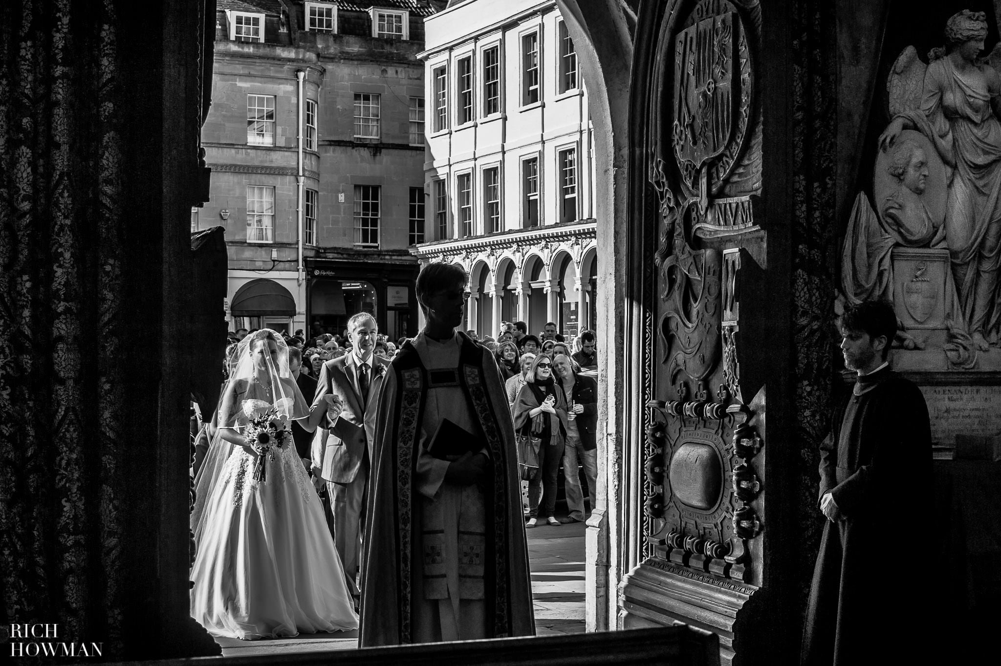 Black and white photo of the bride entering the West Door for her wedding at Bath Abbey