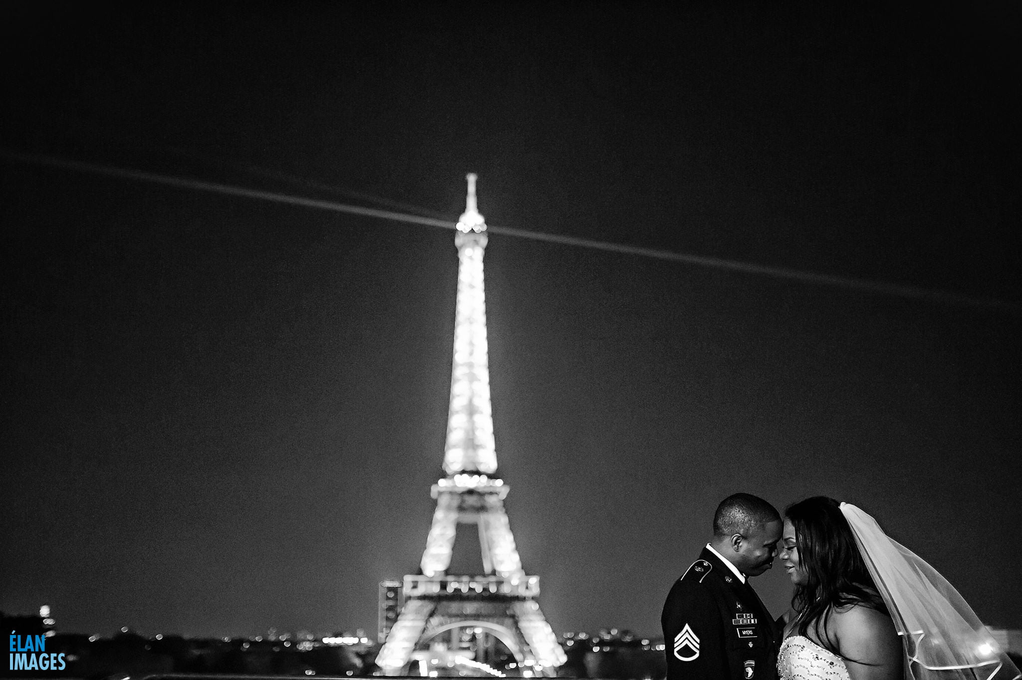The end of a long day - the bride and groom relax and enjoy the evening light show on the Eiffel Tower, after getting married at the American Church in Paris, France.