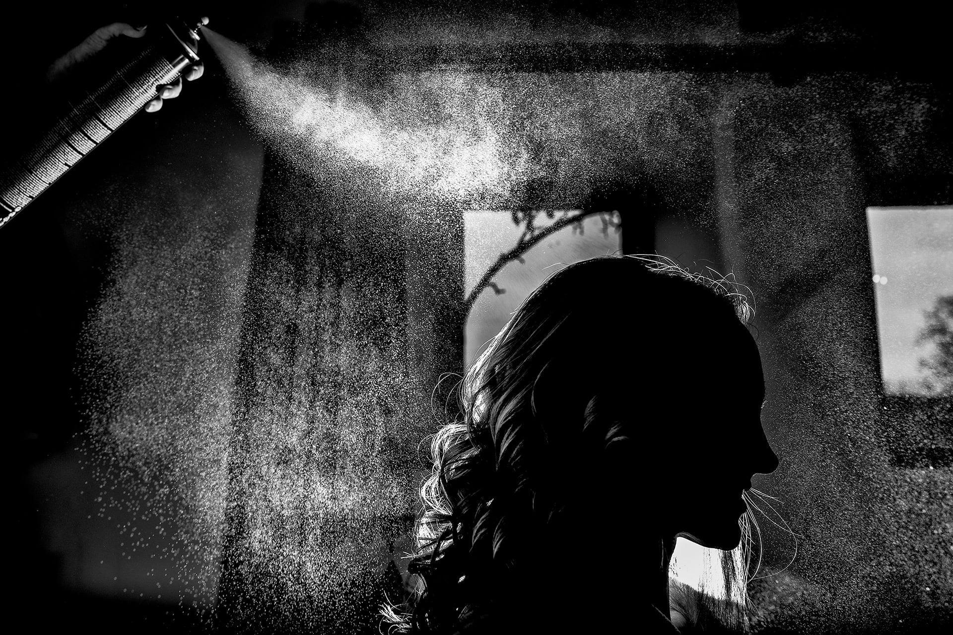 Bride having her hair sprayed before her wedding at the Great Tythe Barn Tetbury