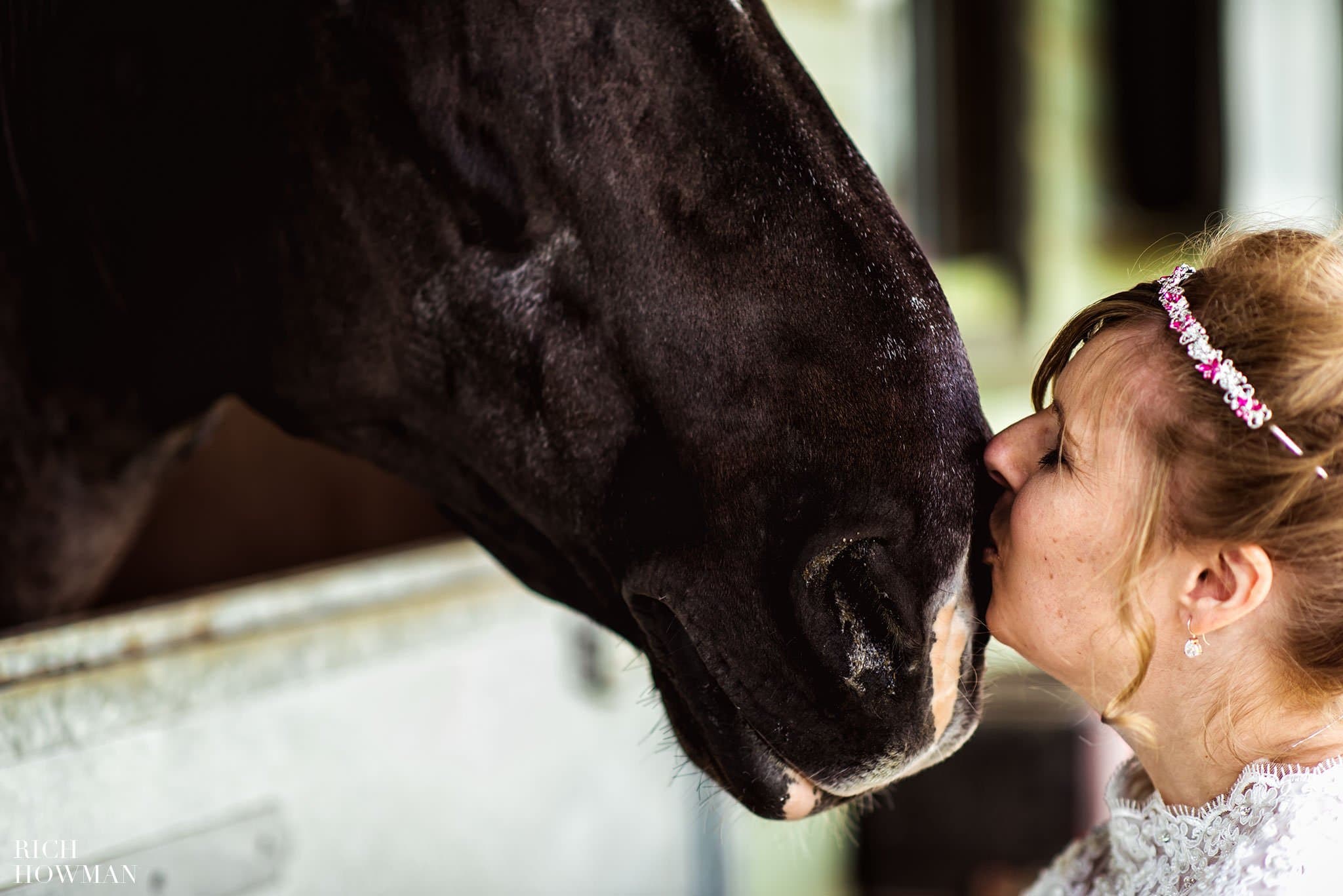 Bride kissign a horse on the nose