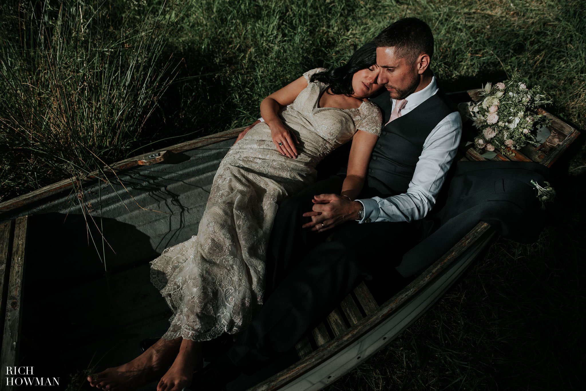 Bride and groom laying in a rowing boat at Iscoyd Park