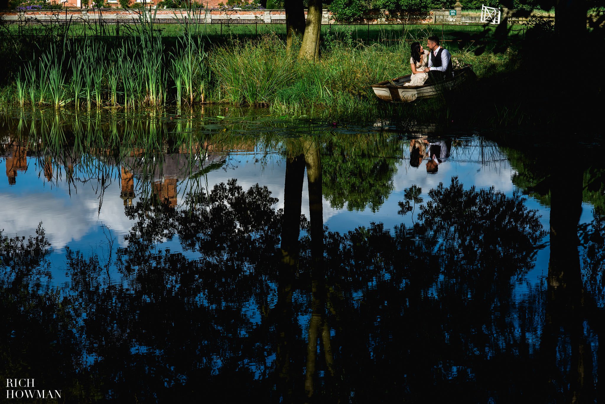 Bride and groom enjoy wedding photographs by the lake at Iscoyd Park