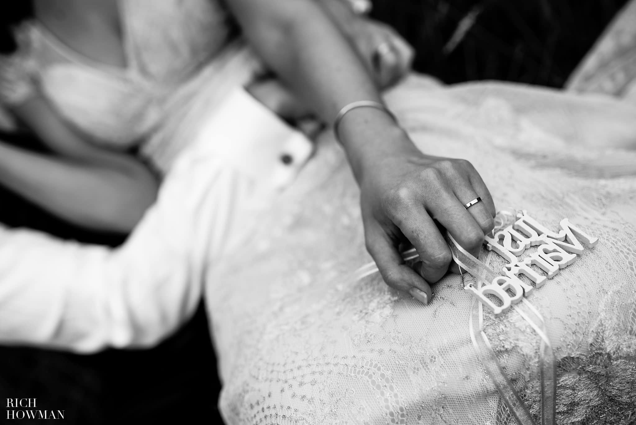 Close up black and white photo of the brides hand and rings