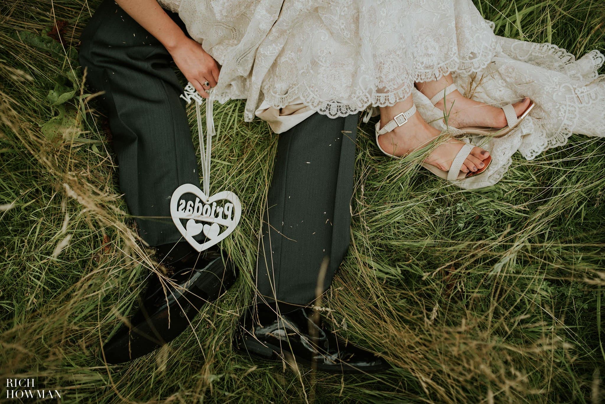 Photograph of the couples feet sitting in the grass during their Iscoyd Park Wedding - Photo by Rich Howman