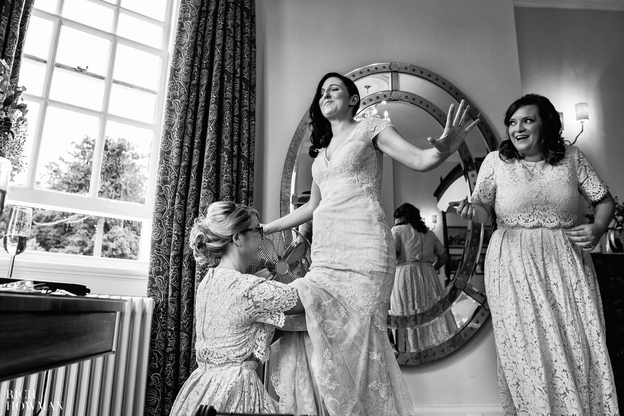 Funny black and white photo of the bride getting her dress on