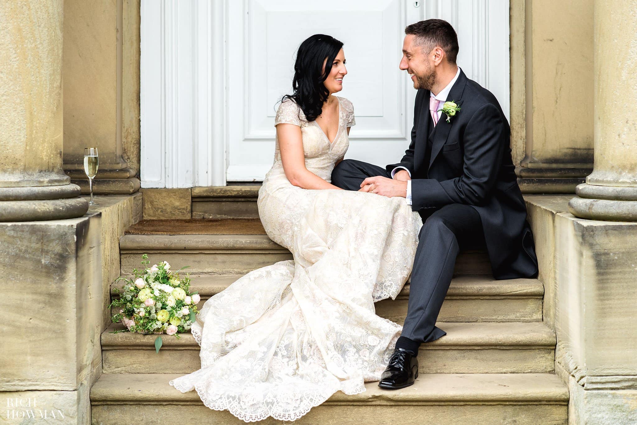 Bride and groom sitting on the steps outside the front door of Iscoyd Park
